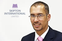 Jim in front of Skipton International Limited logo