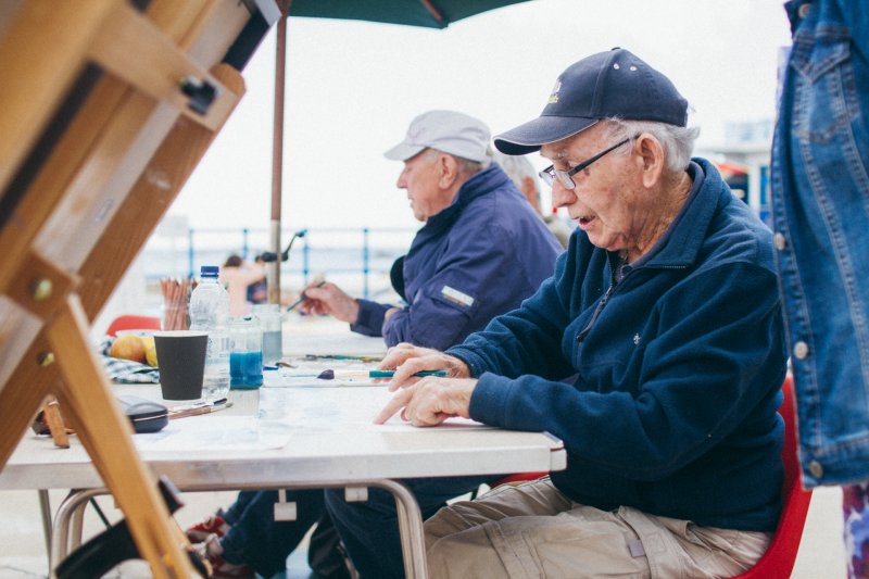 men painting on sea front