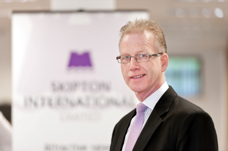Nigel in front of Skipton International Limited logo
