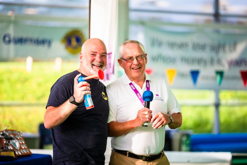 two men holding an airhorn and a microphone