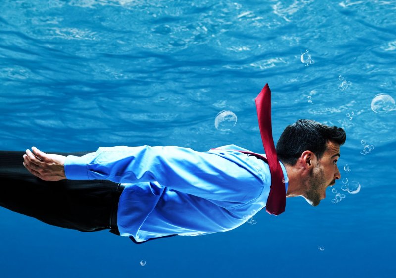 man in suit swimming underwater