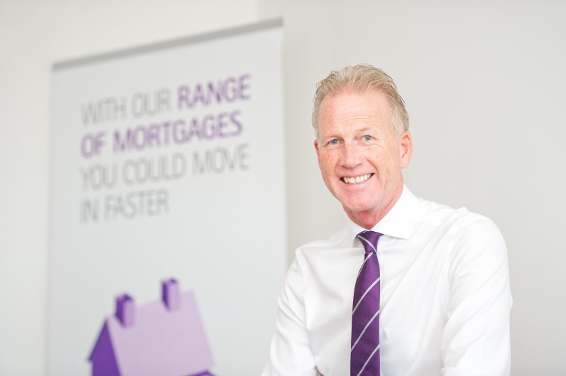 man smiling next to Skipton logo