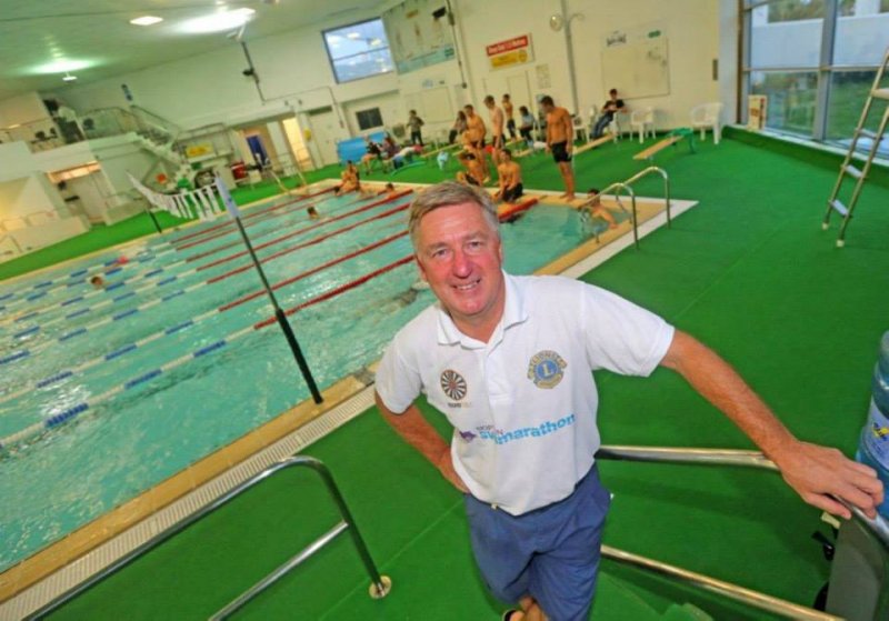 Man smiling next to swimming pool